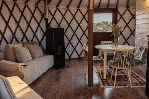 a room with a couch and a table in a yurt at Jurtowe Wzgórze Glamping in Grabinek