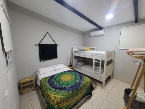 a bedroom with a bed and a bunk bed at LOOKING2GOOD in El Zonte