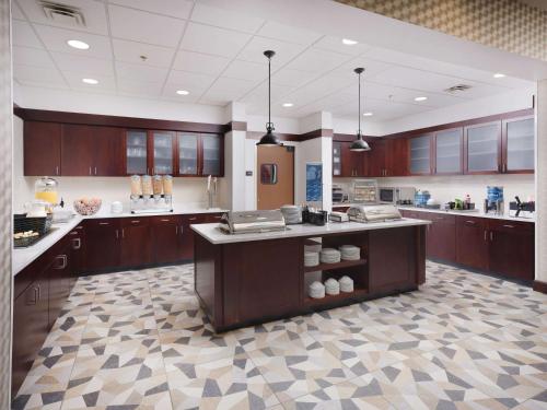 a large kitchen with wooden cabinets and a large island at Homewood Suites by Hilton Atlanta NW/Kennesaw-Town Center in Kennesaw