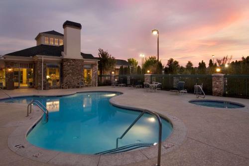 a swimming pool at a resort at night at Hilton Garden Inn Atlanta Northpoint in Alpharetta