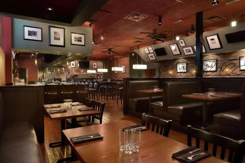 a restaurant with wooden tables and chairs and a bar at DoubleTree by Hilton Atlanta Northeast/Northlake in Atlanta