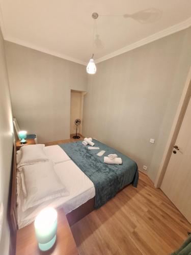 a bedroom with a large bed with slippers on it at Mery's Family Apartment in Tbilisi City