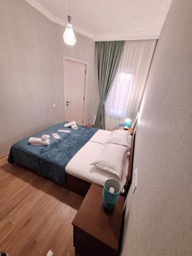 a bedroom with a bed and a table in it at Mery's Family Apartment in Tbilisi City