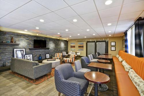 a waiting room with couches and tables and a tv at Hampton Inn Auburn in Auburn