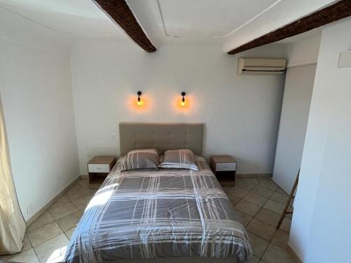 - une chambre avec un lit et deux lumières sur le mur dans l'établissement Duplex vieille ville, à Antibes