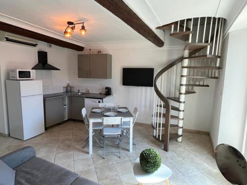 - un salon avec une table et un escalier en colimaçon dans l'établissement Duplex vieille ville, à Antibes