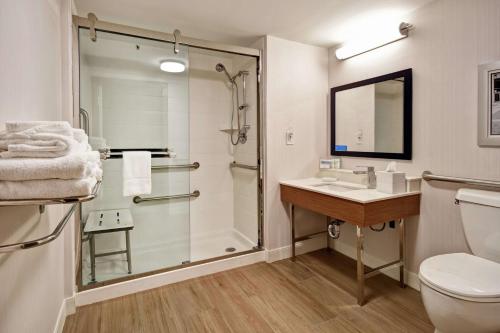 a bathroom with a shower and a toilet and a sink at Hampton Inn Auburn in Auburn