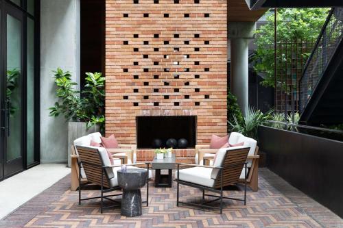 a patio with four chairs and a fireplace at Canopy By Hilton Austin Downtown in Austin