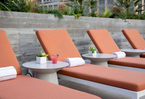 a row of orange chairs with tables and plants at Canopy By Hilton Austin Downtown in Austin