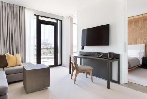 a hotel room with a desk with a bed and a television at Canopy By Hilton Austin Downtown in Austin