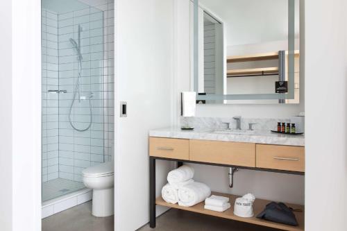 een badkamer met een wastafel, een douche en een toilet bij Canopy By Hilton Austin Downtown in Austin