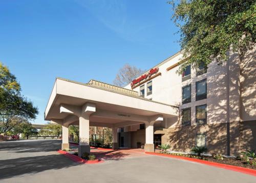 a building with an awning next to a street at Hampton Inn Austin North in Austin