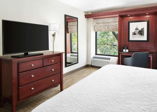 a hotel room with a bed and a flat screen tv at Hampton Inn Austin North in Austin