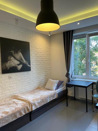 - une chambre avec un lit et une photo sur le mur dans l'établissement Old Town Apartments Rajska, à Gdańsk