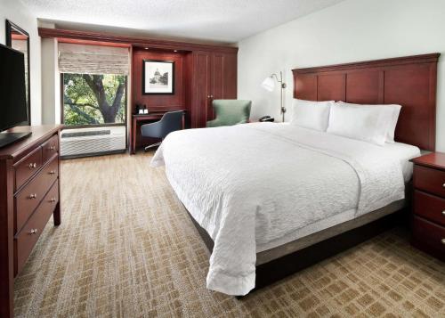 a hotel room with a large bed and a desk at Hampton Inn Austin North in Austin