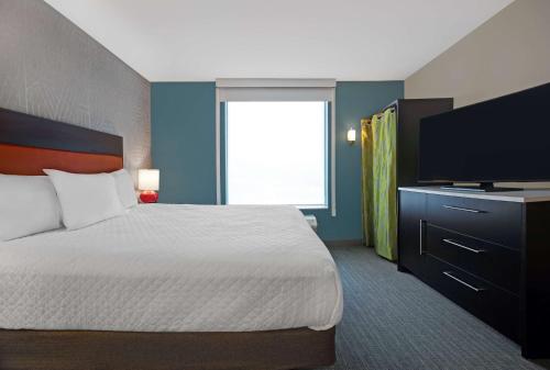 a hotel room with a bed and a flat screen tv at Home2 Suites By Hilton Asheville Airport in Arden