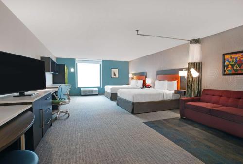 a hotel room with two beds and a flat screen tv at Home2 Suites By Hilton Asheville Airport in Arden