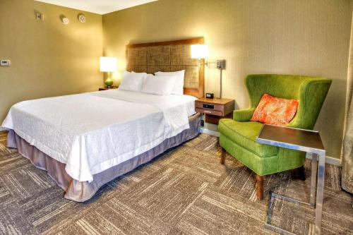 a hotel room with a bed and a chair at Hampton Inn and Suites Asheville Airport in Fletcher