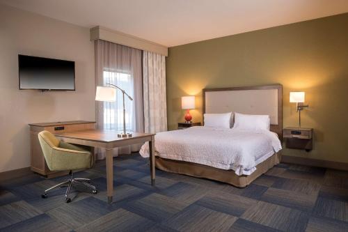 a hotel room with a bed and a desk and a television at Hampton Inn & Suites-Asheville Biltmore Village, NC in Asheville