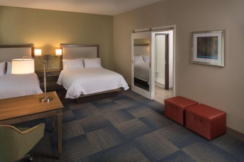 a hotel room with two beds and a table and a desk at Hampton Inn & Suites-Asheville Biltmore Village, NC in Asheville