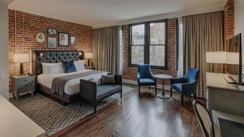 a hotel room with a bed and a desk and chairs at Foundry Hotel Asheville, Curio Collection By Hilton in Asheville