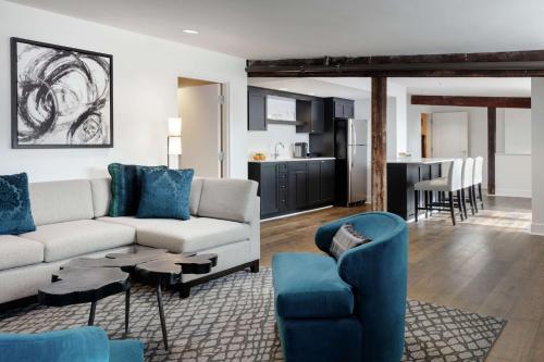 a living room with a white couch and blue chairs at Foundry Hotel Asheville, Curio Collection By Hilton in Asheville