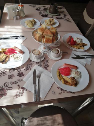 a table with plates of breakfast food on it at OUR House in Vagharshapat