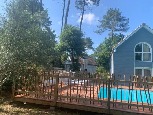 une clôture autour d'une piscine en face d'une maison dans l'établissement maison bleue, à Biscarrosse