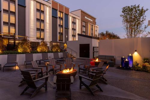 a patio with chairs and a fire pit in front of a building at Hilton Garden Inn Asheville South in Asheville
