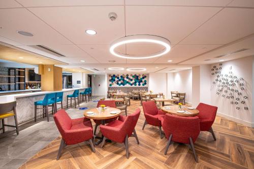 a restaurant with tables and chairs and a bar at Hilton Garden Inn Asheville South in Asheville
