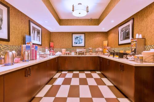 a kitchen with wooden cabinets and a checkered floor at Hampton Inn Hendersonville in Hendersonville