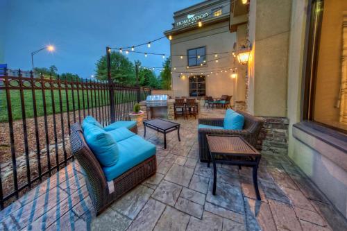 a patio with chairs and tables and a fence at Homewood Suites by Hilton Asheville in Asheville