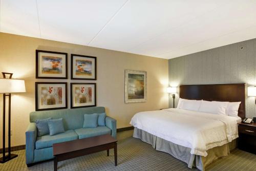 Habitación de hotel con cama y sofá azul en Hampton Inn & Suites Wilkes-Barre en Wilkes-Barre