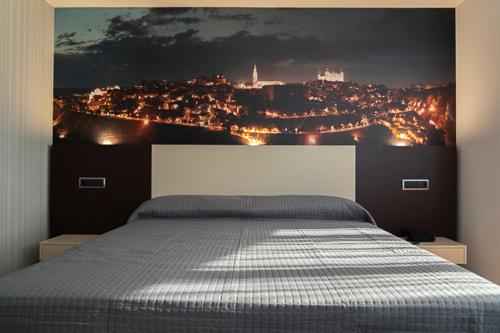 a bedroom with a bed with a view of a city at Hotel-Asador Montes Oretanos in Pulgar