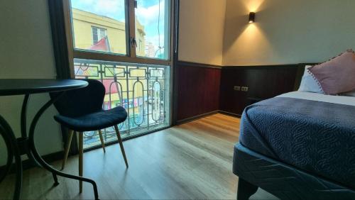 a bedroom with a bed and a chair and a window at Hotel Asturias in Viña del Mar
