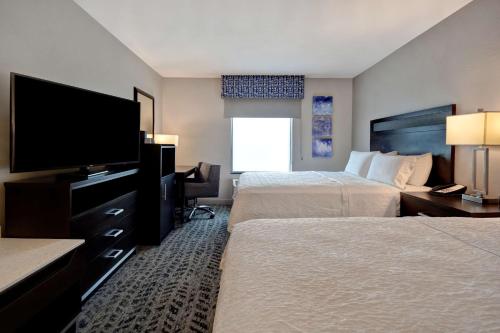 a hotel room with two beds and a flat screen tv at Hampton Inn & Suites - Columbia South, MD in Columbia