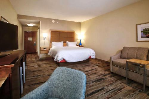a hotel room with a bed and a couch at Hampton Inn & Suites By Hilton Baltimore/Aberdeen, Md in Aberdeen