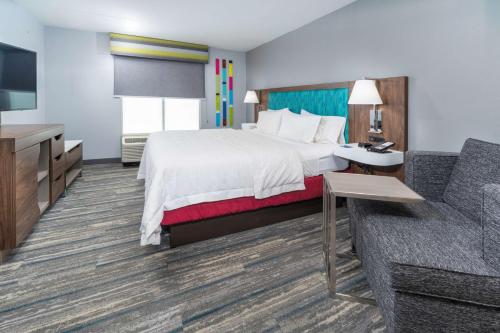 a hotel room with a bed and a couch at Hampton Inn Swedesboro Philadelphia in Swedesboro