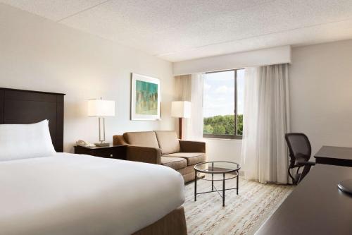 a hotel room with a bed and a couch at DoubleTree by Hilton Bradley International Airport in Windsor Locks