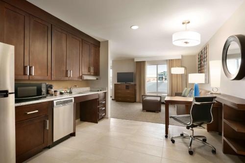 a kitchen with a desk and a table with a chair at Homewood Suites By Hilton Hartford Manchester in Manchester