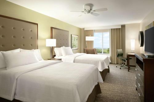 a hotel room with two beds and a television at Homewood Suites By Hilton Hartford Manchester in Manchester