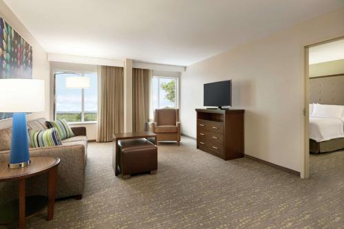 a hotel room with a couch and a bed and a television at Homewood Suites By Hilton Hartford Manchester in Manchester