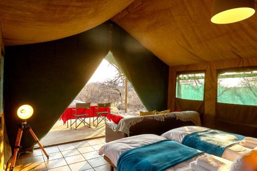ZuriCamp - Tent Zahir في تسومب: غرفة نوم بسريرين في خيمة