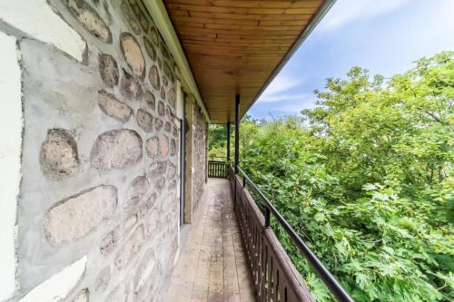 a balcony with a stone wall and a wooden ceiling at Le Buisset cosy 4 pers La Mulatière in La Mulatière