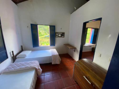 a bedroom with two beds and a couch in it at Solar dos Pássaros in Pacoti