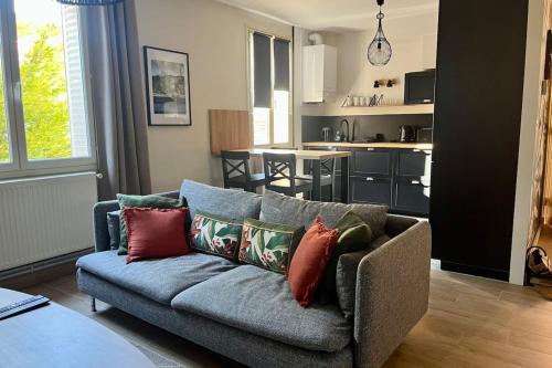 - un salon avec un canapé et des oreillers dans l'établissement Le Perralieres charmant 2 chambres métro Flachet, à Villeurbanne
