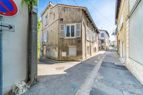 eine Gasse mit einem alten Gebäude und einem Straßenschild in der Unterkunft Le Pablo charmant 6 pers Sainte-Foy-lès-Lyon in Sainte-Foy-lès-Lyon