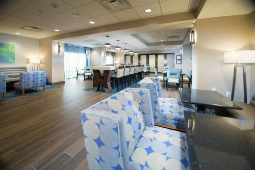 a waiting room with blue and white chairs and a table at Hampton Inn Arvin Tejon Ranch, Ca in Wheeler Ridge