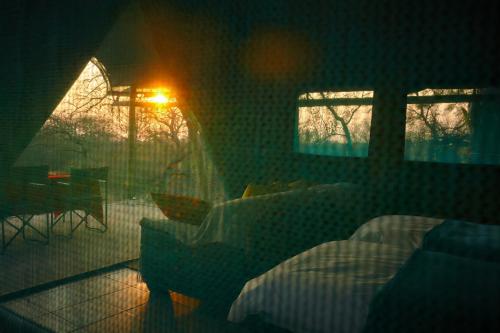 a room with a bedroom with a bed and a table at ZuriCamp - Tent Zahir in Tsumeb