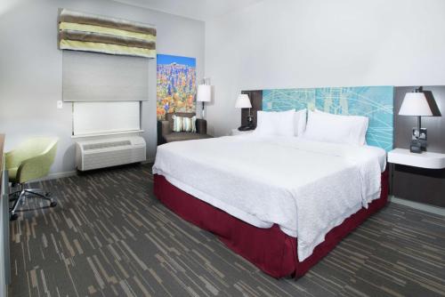 una camera d'albergo con un grande letto e una sedia di Hampton Inn Arvin Tejon Ranch, Ca a Wheeler Ridge